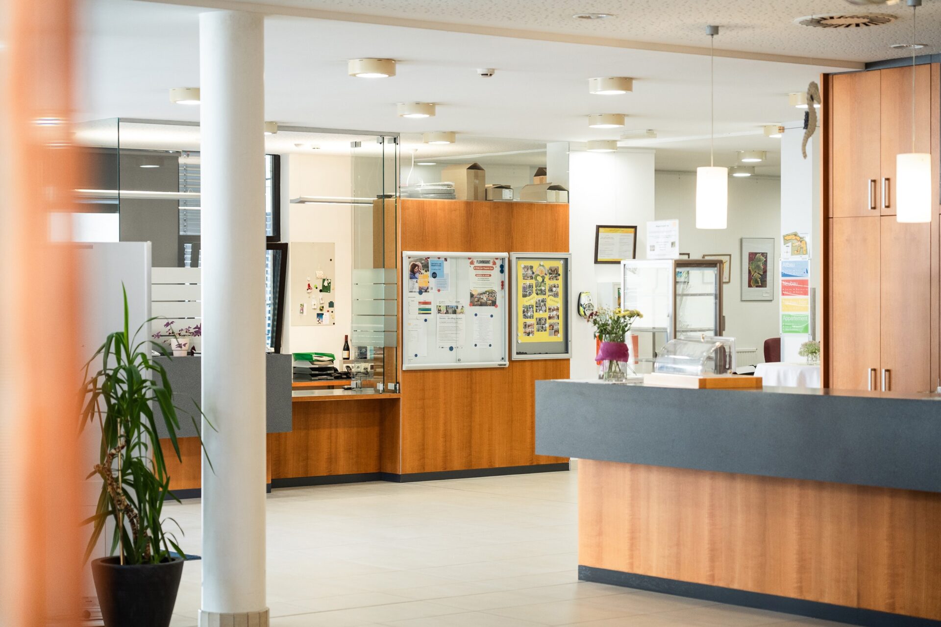 Empfangsbereich im Wohn- und Pflegeheim Lienz mit Rezeption, Informationsbereich und heller Innenarchitektur.